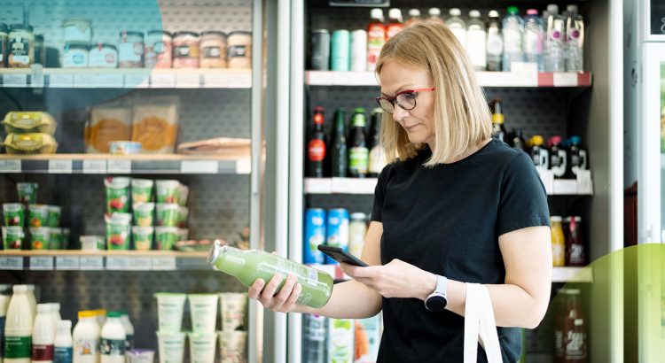 Mulher conferindo rótulo de embalagem de produto no supermercado